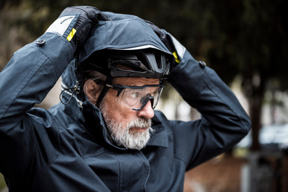 Älterer Man mit Helm und einem Dunklen Fahrradmantel an.